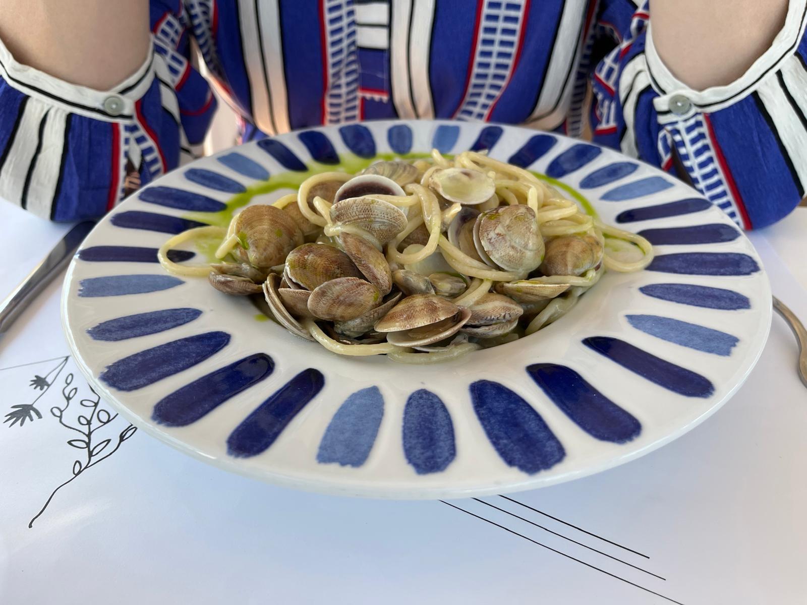 Spaghetti alle vongole on a hand-painted plate by the Adriatic